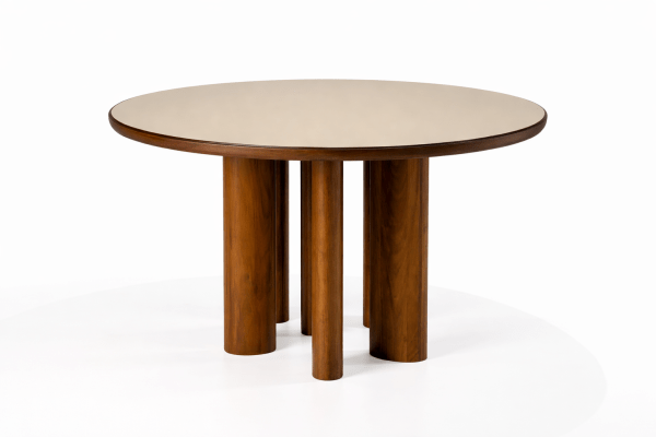 Mesa Serena con sobre de vidrio en tono nude y base escultórica en madera. Su diseño moderno combina elegancia y carácter, convirtiéndose en el centro visual del comedor.