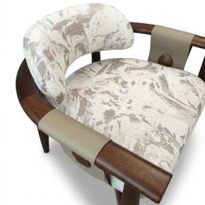 Poltrona Brava diseñada por Eduardo Trevisan, con estructura de madera en tono nogal, tapizado M01 en tonos beige y crema con diseño abstracto y detalles en cuero beige.