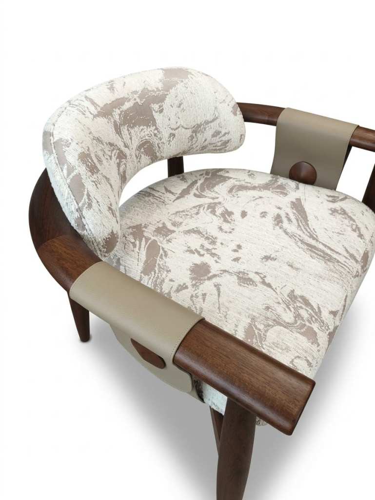 Poltrona Brava diseñada por Eduardo Trevisan, con estructura de madera en tono nogal, tapizado M01 en tonos beige y crema con diseño abstracto y detalles en cuero beige.